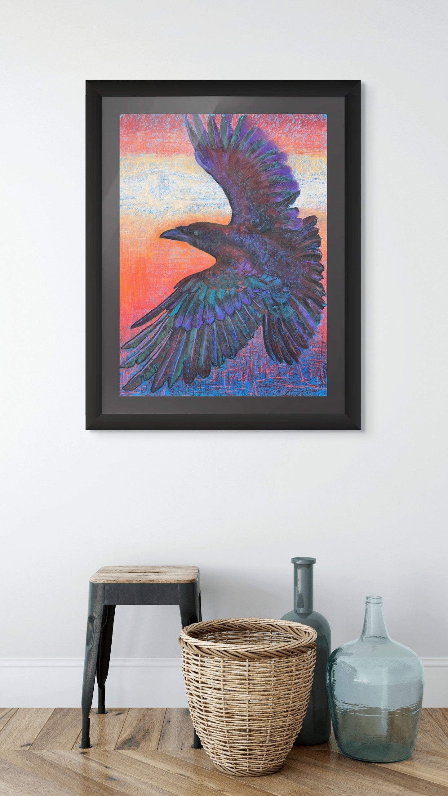Room mockup of Sunset Thermals by Georgia Edwards, showing a framed raven artwork above a stool, basket, and glass bottles in a minimal interior.