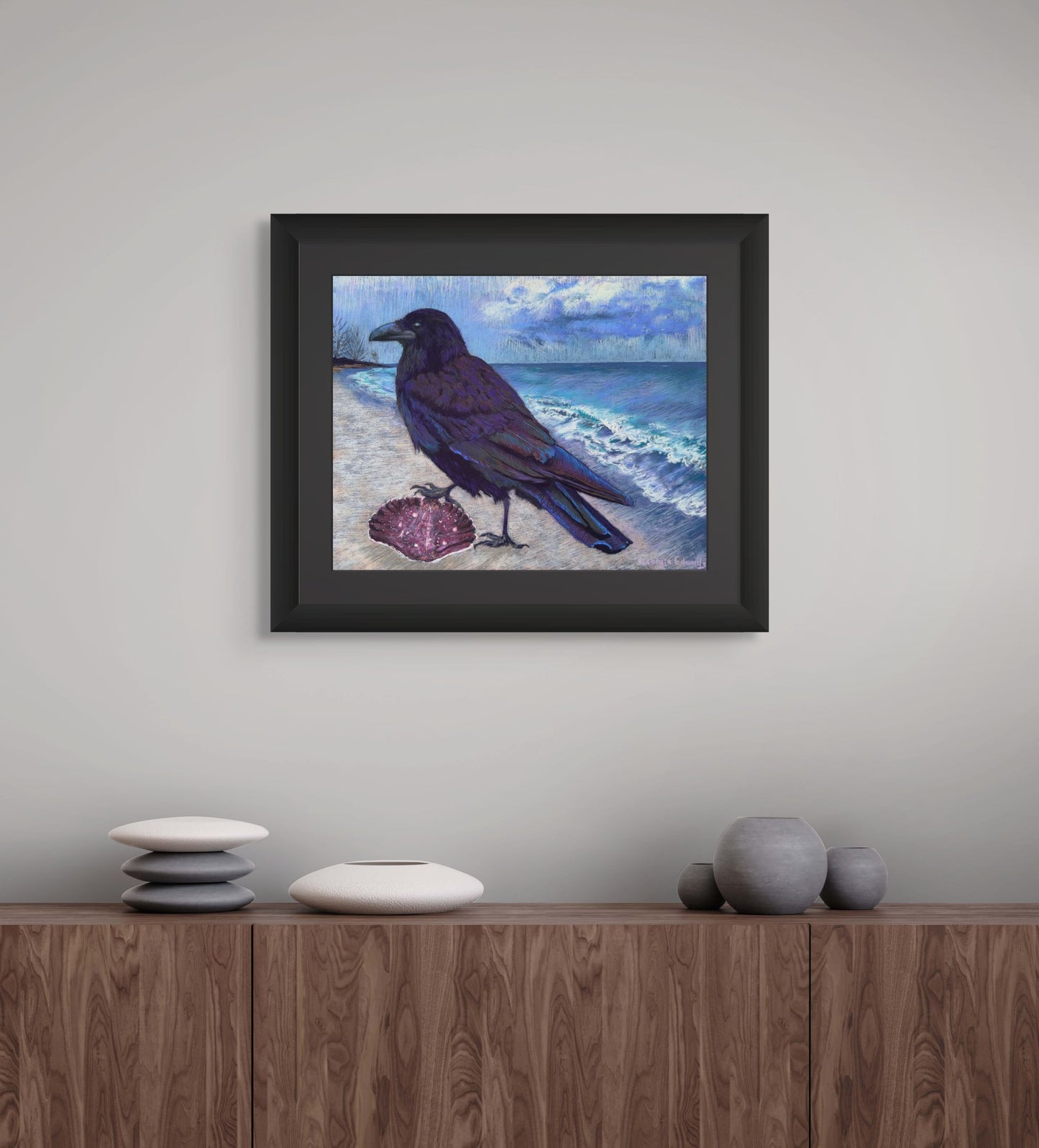 Room mockup of A Winter Walk by Georgia Edwards, showing a framed raven painting above a wooden cabinet in a calm modern interior.