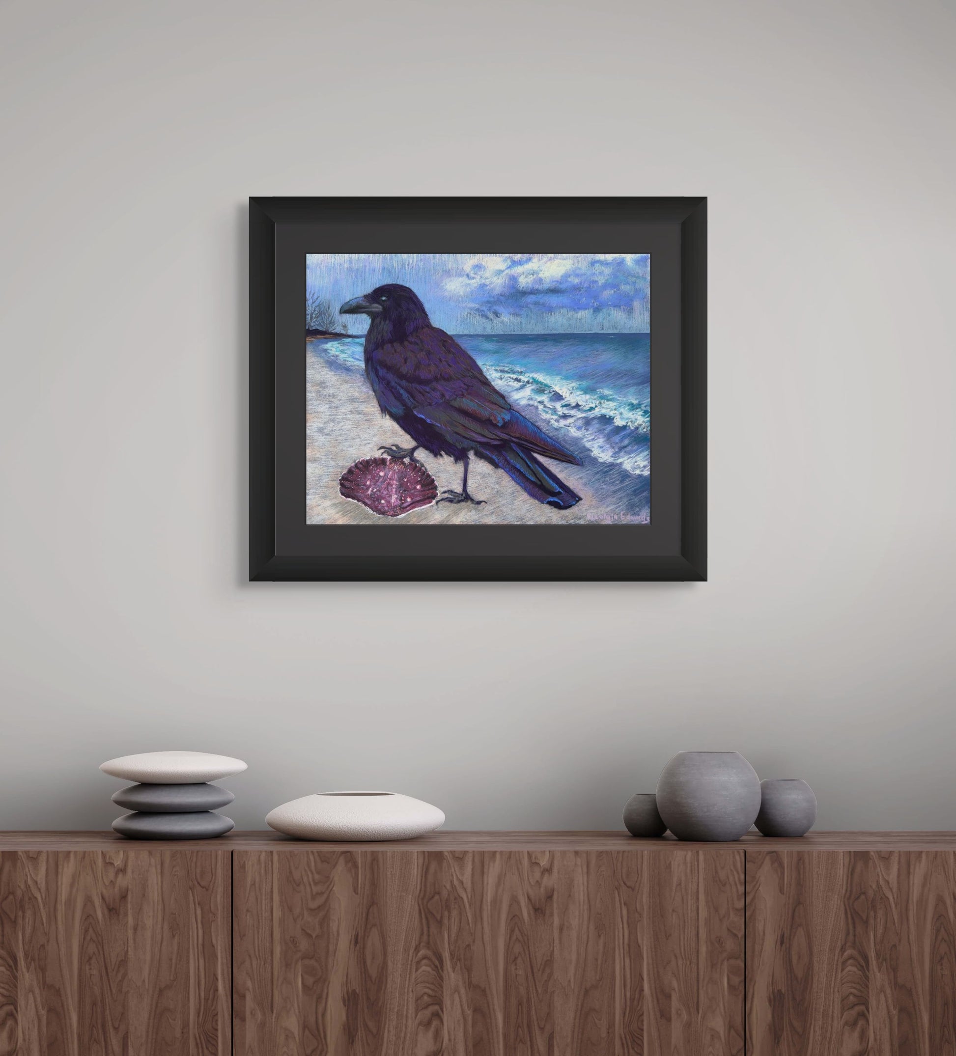 Room mockup of A Winter Walk by Georgia Edwards, showing a framed raven painting above a wooden cabinet in a calm modern interior.