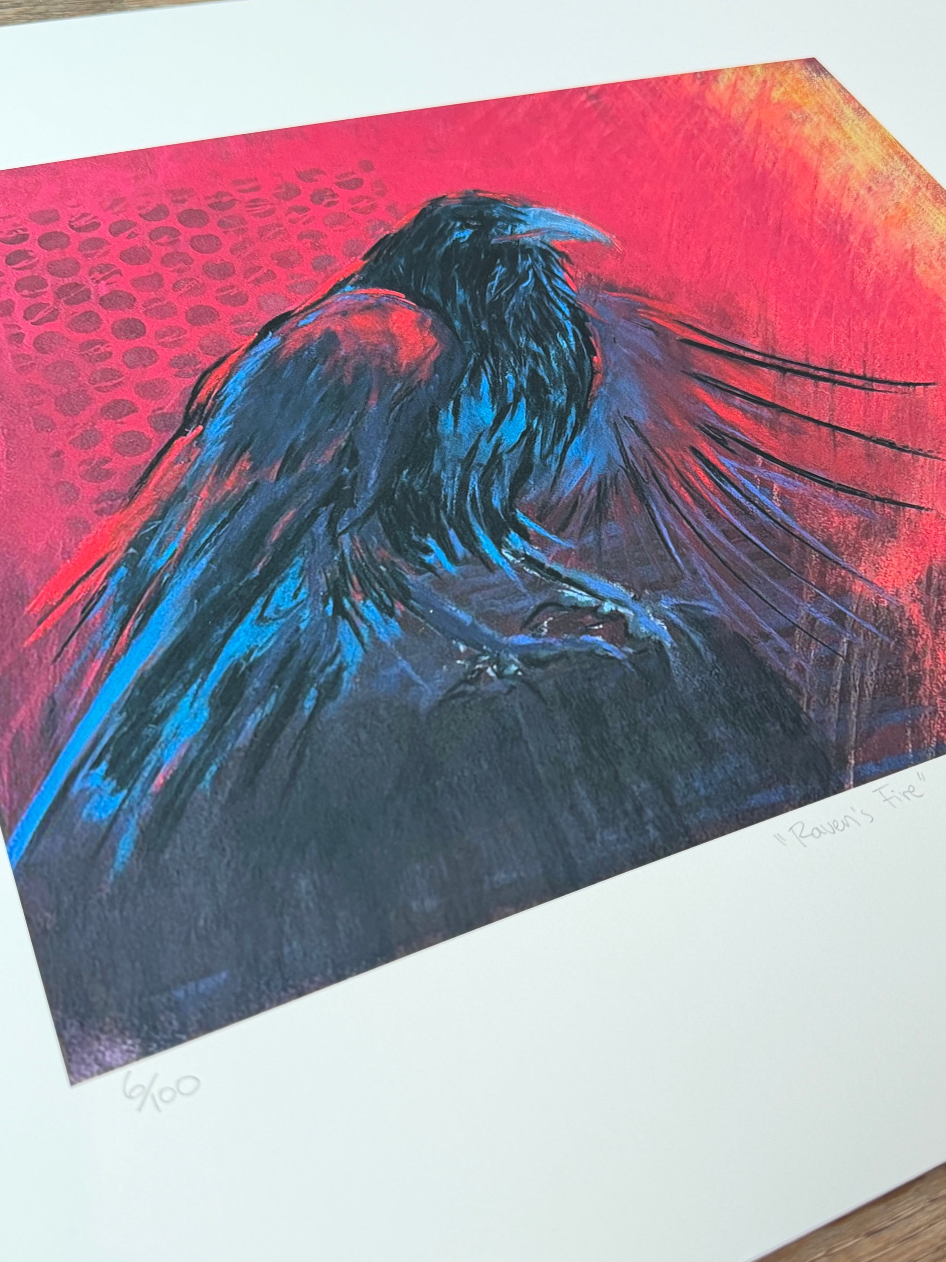 Artistic depiction of a bird in flight with red and blue colors on a textured surface. Limited Edition print of a raven painting by artist Georgia Edwards