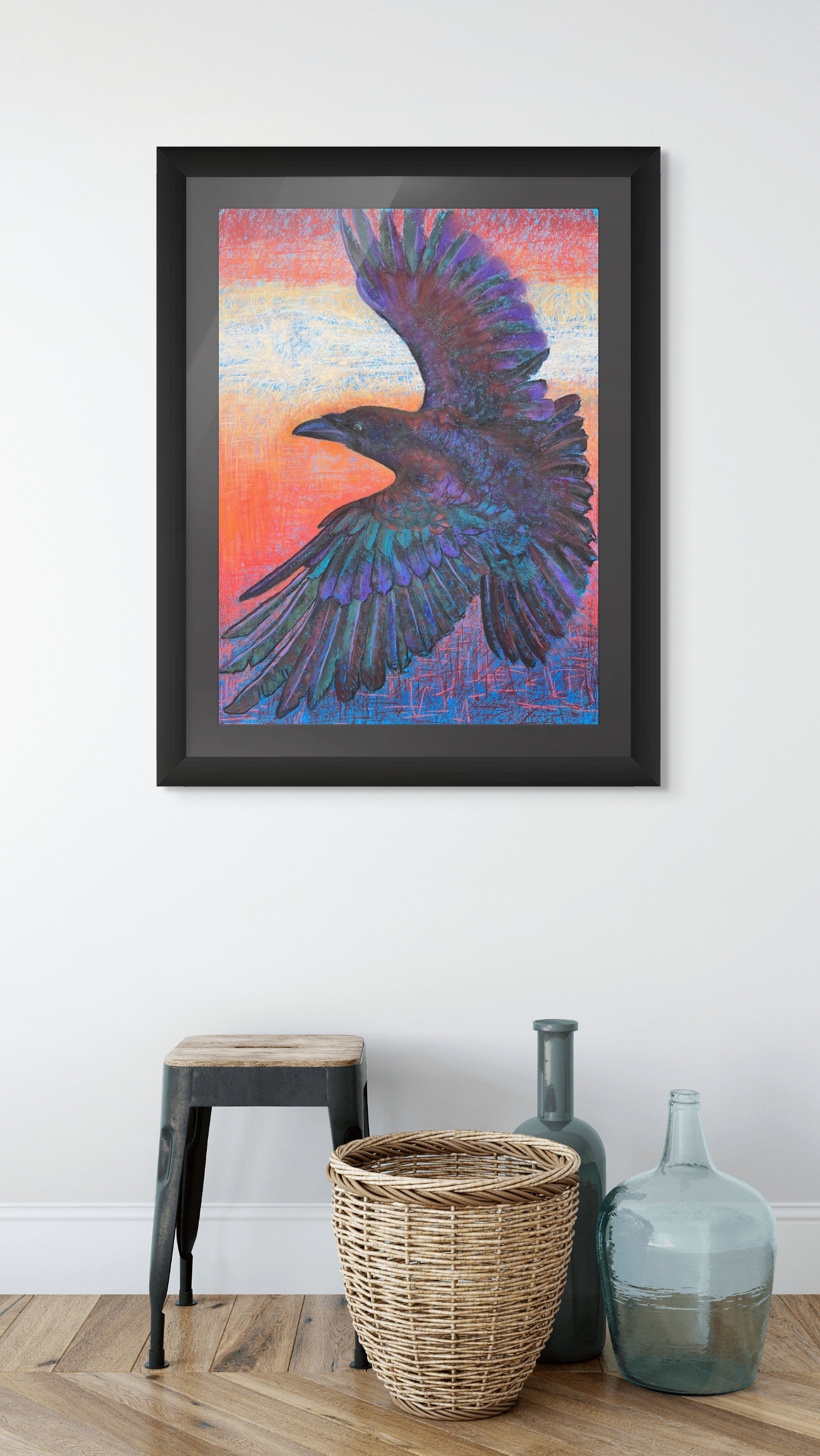 Room mockup of Sunset Thermals by Georgia Edwards, showing a framed raven artwork above a stool, basket, and glass bottles in a minimal interior.